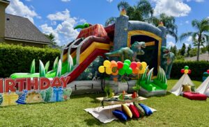 dinosaur birthday party setup Odessa Florida with bounce house balloon decor and kids table